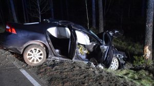 Na zdjęciu widać bokiem ustawiony na drodze ciemny pojazd marki Volvo, który uderzył przodem w przydrożne drzewo.
