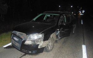 W nocy widać na drodze stojący pojazd marki Audi  koloru ciemnego. Jest uszkodzne z przodu od strony kierowcy.