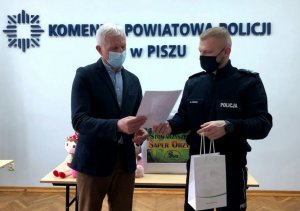Komendant Powiatowy wręcza Prezesowi Stowarzyszenia podziękowanie za zabawki.