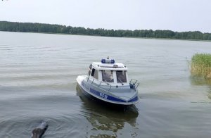 Policyjna łódź pływająca po jeziorze.