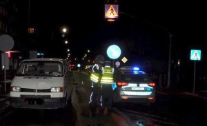 W ciemności dwa samochody, w tym oznakowany radiowóz, stojące przy przejściu, gdzie doszło do wypadku.