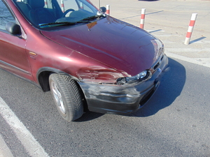 Widoczny uszkodzony przedni prawy narożnik samochodu osobowego.