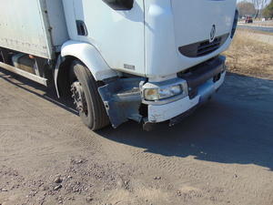 Widoczny jest uszkodzony prawy przedni narożnik samochodu ciężarowego.