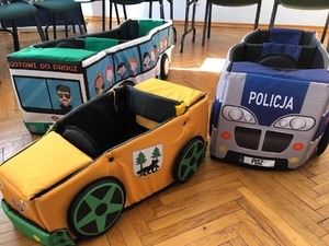 Na zdjęciu widoczne trzy zabawkowe pojazdy. Na środkowym widoczne jest logo powiatu piskiego