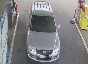 Na stacji benzynowej przy dystrybutorze stoi przodem samochód w srebrnym kolorze.