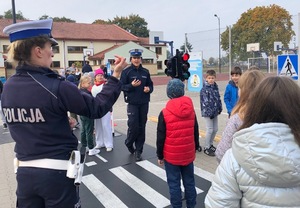 Policjantki z ruchu drogowego rozmawiają z dziećmi na boisku w miasteczku ruchu drogowego.