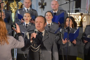 W kościele przed ołtarzem stoi policyjny chór, którzy śpiewa.