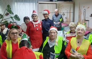 Pamiątkowe zdjęcie policjantki z seniorami podczas spotkania.