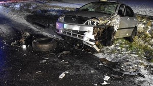 Droga noca. Po prawej w rowie znajduje się srebrny samochód przodem w kierunku drogi. Ma rozbity przód.