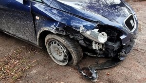 Na zdjęciu ciemny samochód osobowy z rozbitym przodem.