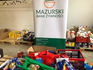 Magazyn spożywczy. W tle baner banku żywności.