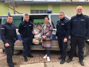 Pamiątkowe zdjęcie na tle radiowozu.