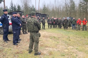 na polanie w lesie stoją przedstawiciele różnych służb.