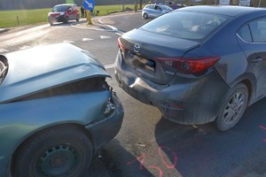 Na drodze stoją dwa samochody osobowe.