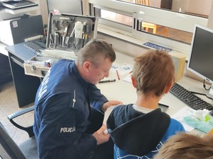 Uczniowie oglądają policyjny sprzęt.