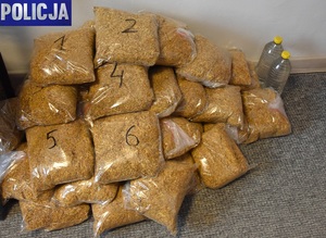 Na podłodze leżą worki z tytoniem , a po prawej stoją dwie butelki ze spirytusem