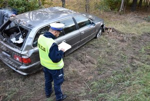 Policjant wykonujący oględziny samochodu