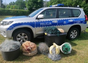 Zabezpieczone sieci rybackie na tle radiowozu
