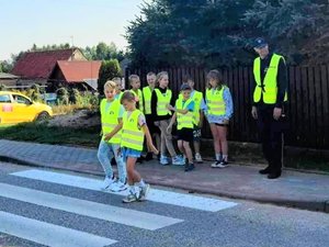 Dzielnicowy uczy dzieci bezpiecznego przechodzenia przez ulicę